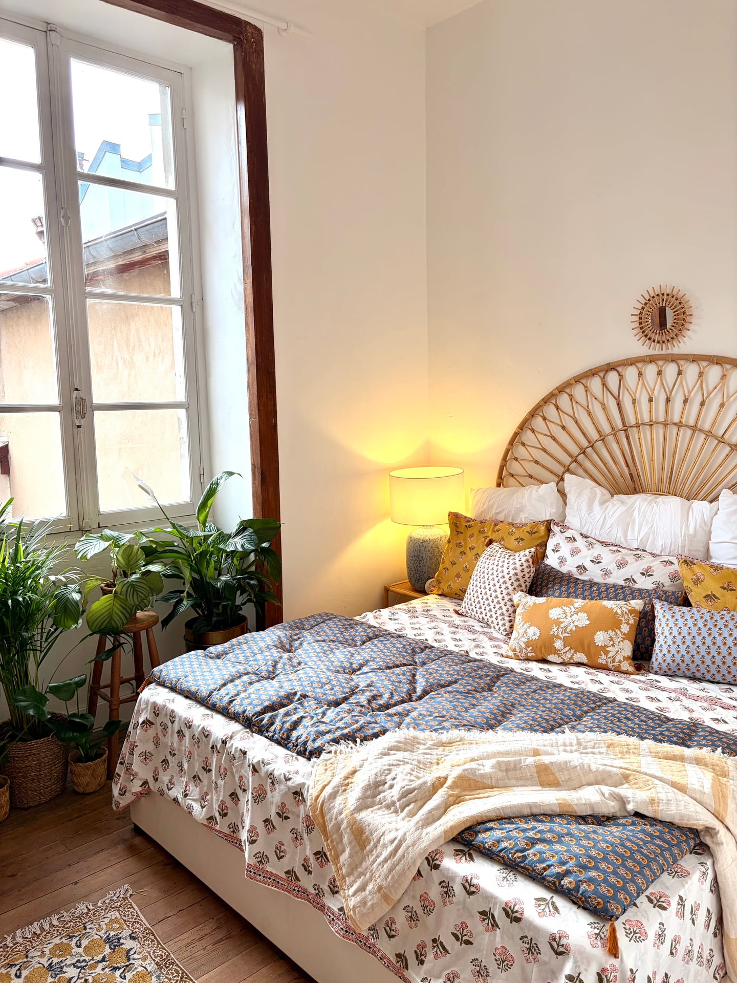 First bedroom window with plants in baskets and lamplight