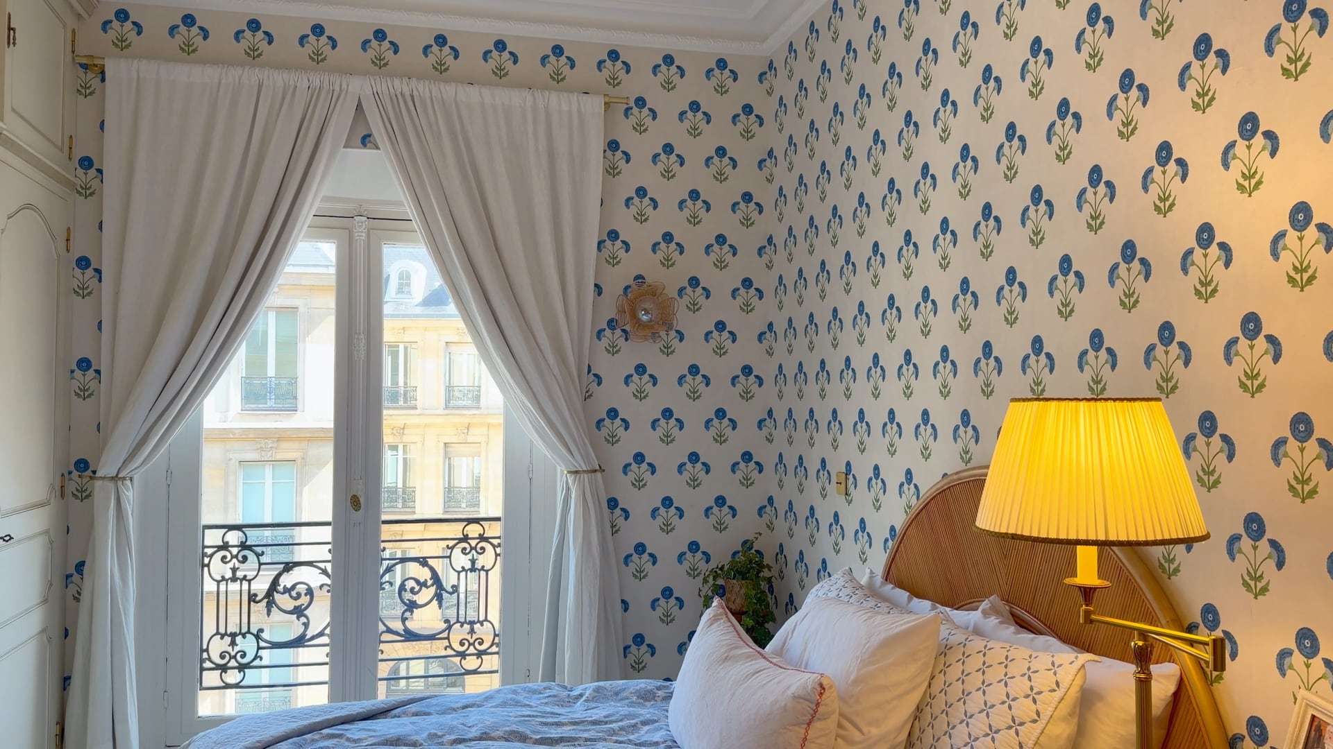 The bed by the curtained balcony windows