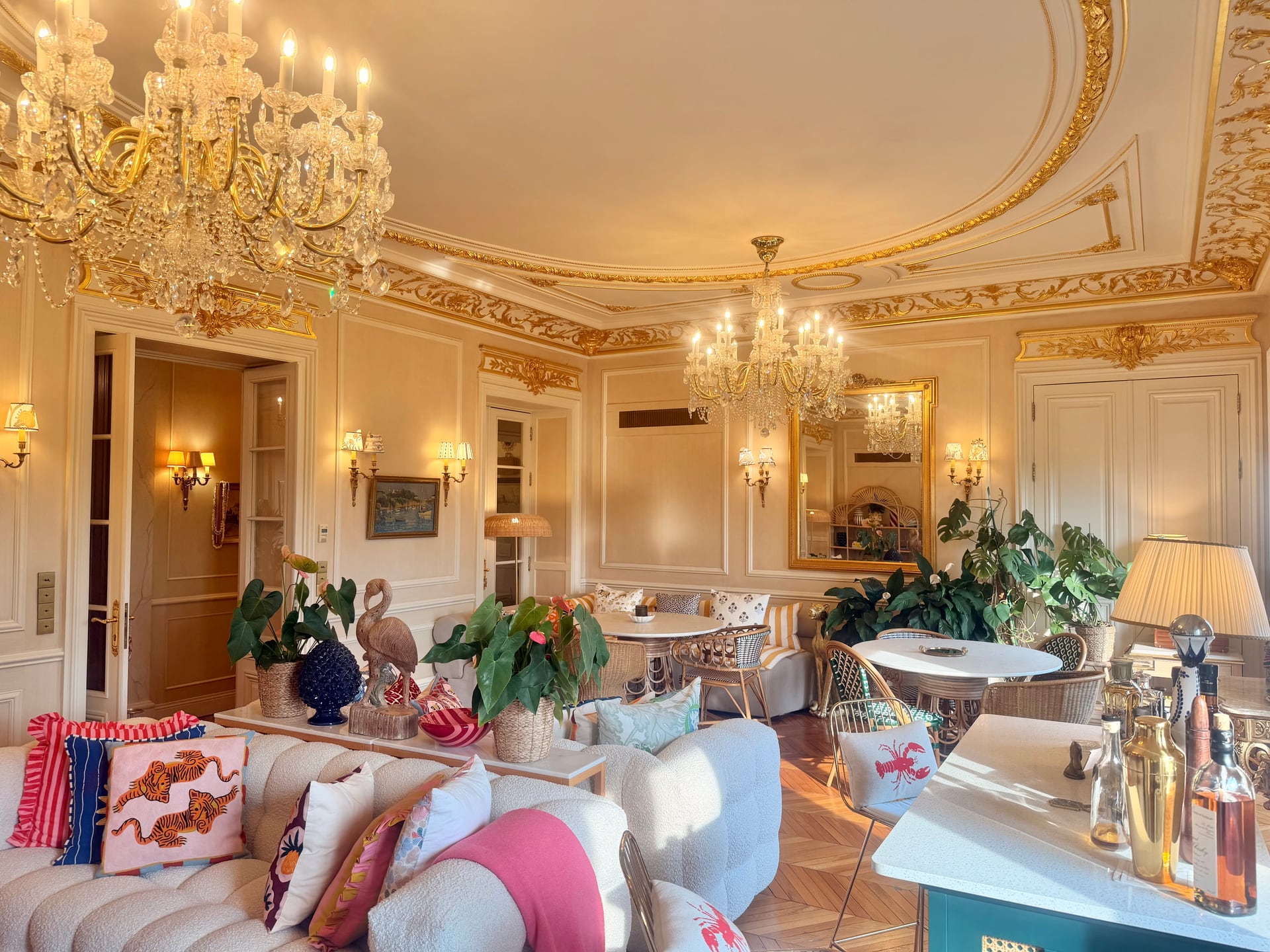 Sofas with patterned cushions and the drinks cart under the chandeliers