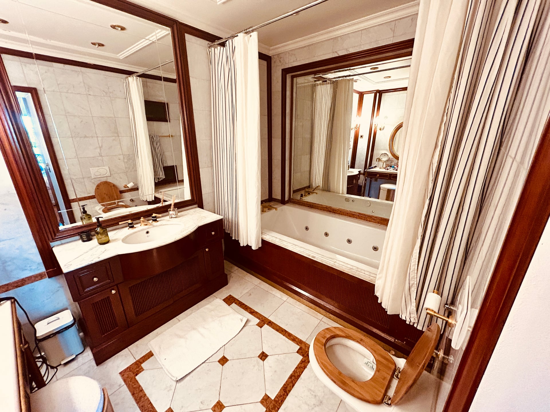 Dark wood and marble bathroom with tub and double sink
